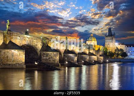 Scenic view of of the Vltava river, Charles Bridge and Old Town Bridge Tower in Prague in the late evening against a dramatic sky. Czech Republic