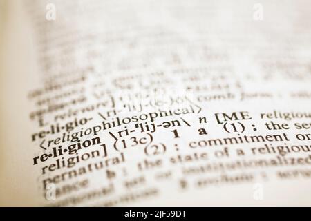 Close-up of the word Religion and definition in dictionary. Stock Photo
