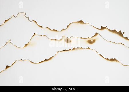 Stack of paper with burnt edges on white Stock Photo