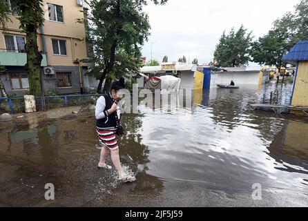 KYIV, UKRAINE - JUNE 29, 2022 - A woman walks along a flooded street after the downpour, Kyiv, capital of Ukraine. This photo cannot be distributed in the russian federation. Stock Photo