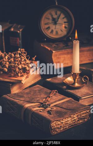 Antique leather-bound journal, book or diary with old books and candle Stock Photo