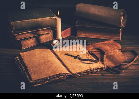Blank antique leather-bound journal, book or diary with old books and candle Stock Photo