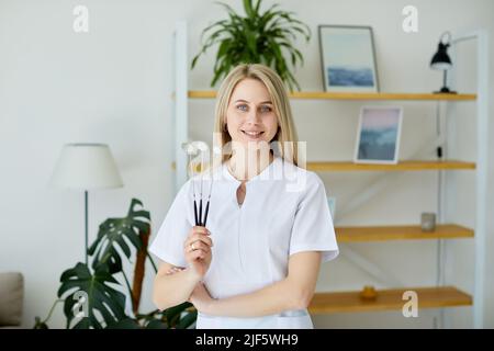 Woman doctor holds a dentist dental mirror in her hand. Medical instrument for oral examination Stock Photo