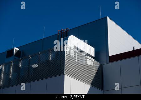 Ventilation and air conditioning systems on the roof of a modern building. HVAC system photographed against a blue sky on a sunny afternoon Stock Photo