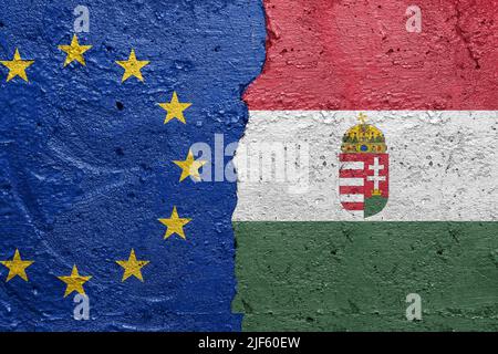 European Union and Hungary flags  - Cracked concrete wall painted with a EU flag on the left and a Hungarian flag on the right Stock Photo