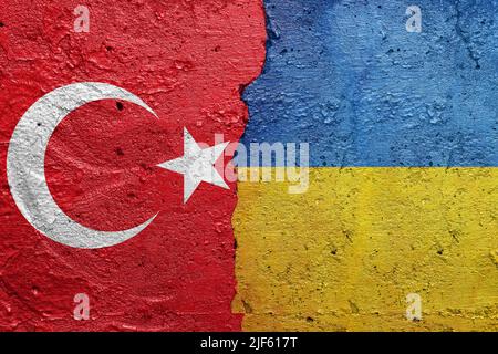Turkey and Ukraine - Cracked concrete wall painted with a Turkish flag on the left and a Ukrainian flag on the right Stock Photo