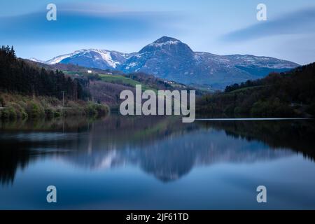 Ibiur reservoir with Txindoki mountain as background, Basque Country in Spain Stock Photo
