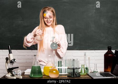 Chemical experiment. Funny schoolgirl kid doing experiments in the laboratory. Explosion in the lab. Science and education. Little girl chemical Stock Photo