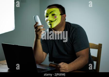 scammer calls the victim holding bank credit cards in his hand, internet scammer Stock Photo