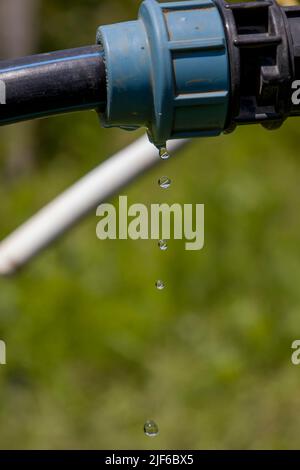 Drops of water falling from the pipe. Stock Photo