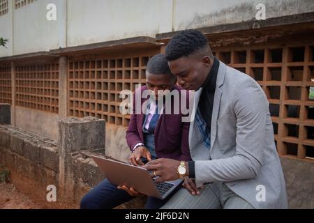 Two colleagues working an a project together look at a laptop screen, synergy and work together concept Stock Photo