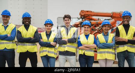 Multiracial engineers working inside robotic factory - Focus on center faces Stock Photo