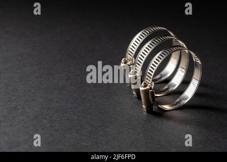 Metal hose clamp on black background. Empty space for text Stock Photo