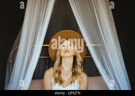 Content Asian male browsing mobile phone and looking at screen while sitting in cafe Stock Photo