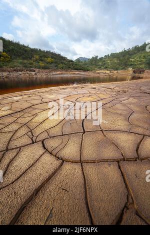 Coast of river with cracked soil located against cloudy sky in daytime in countryside near Minas de Riotinto town in Huelva province, Spain Stock Photo