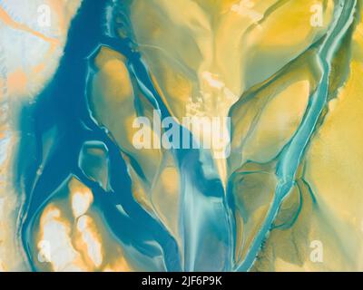 Top view of abstract textured background with colorful yellow and blue stains creating curved swirls and creative patterns Stock Photo