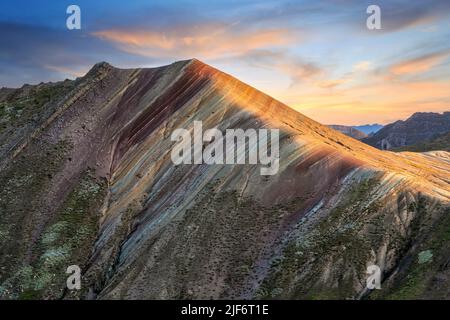 Breathtaking scenery of massive mountain range of Palccoyo with colorful grassy slopes against scenic sunset sky in Peru Stock Photo