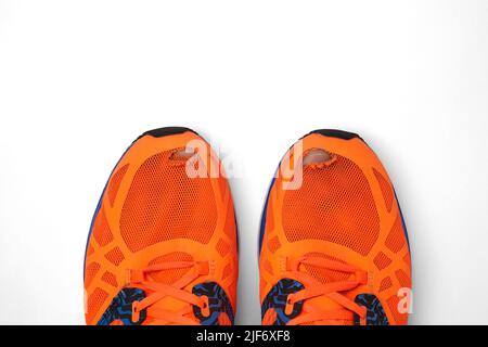 Worn, holey running shoes with real legs sticking out of them. Daily enhanced exercise Stock Photo