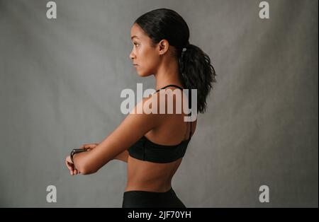 Close up of focused African American woman fixing her smart watch Stock Photo