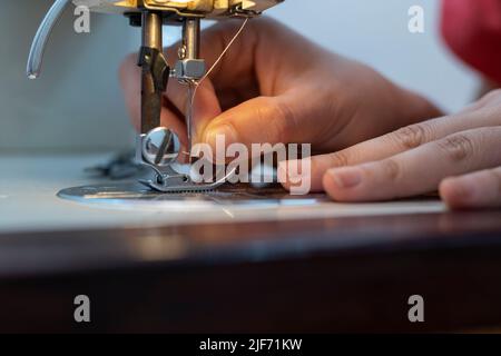 Female tailor's hands using a sewing machine Stock Photo
