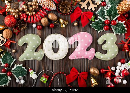 Colorful stitched digits 2022 of polkadot fabric with Christmas decorations flat lay  background on wooden table Stock Photo