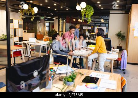 Multiracial male and female architects with architectural model in office Stock Photo