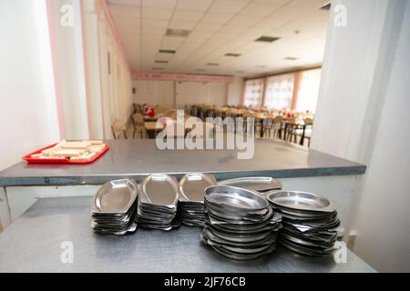 Iron plates in the background of a public dining room.School breakfast in a Russian school Stock Photo