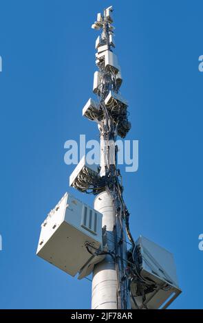 Telecommunication cell tower antenna against blue sky. Wireless communication and modern mobile internet. Stock Photo