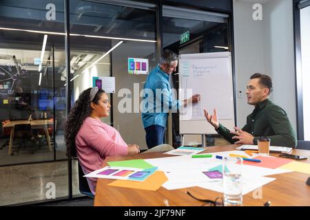 Multiracial businessman and businesswoman discussing strategy in meeting at office Stock Photo