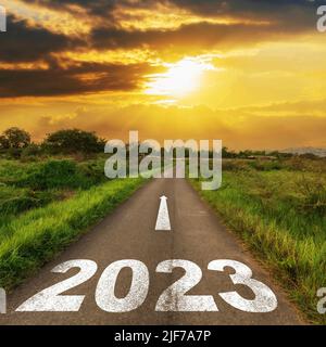 Empty asphalt road and New year 2023 concept. Driving on an empty road to Goals 2023 with sunset. Stock Photo