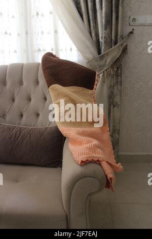Knitted blanket on the sofa in tv room, Stock Photo