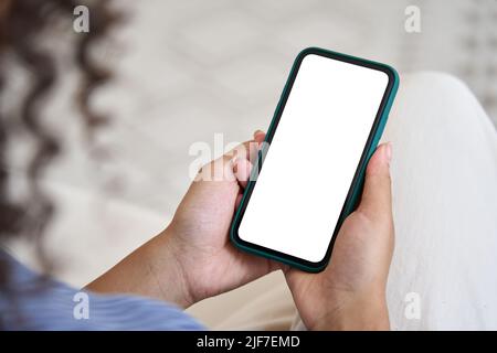 Young woman user holding smart phone mock up white screen in hands. Stock Photo