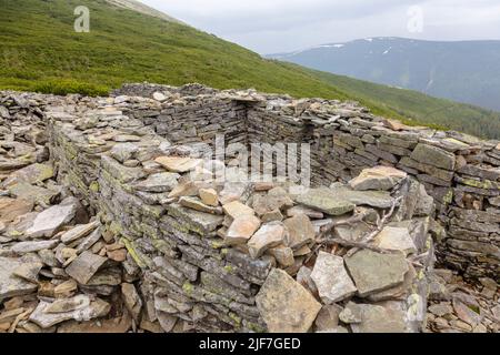 Stone fortification wall from the First World War covered with yellow moss, Carpathians, Ukraine Stock Photo