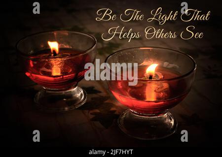 Inspirational quote - Be the light that helps others see. With candle light in wine glass. Stock Photo