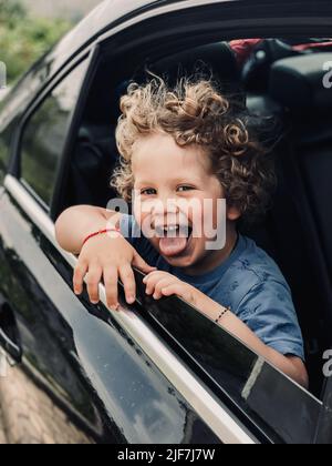 blond boy looking out of car window Stock Photo