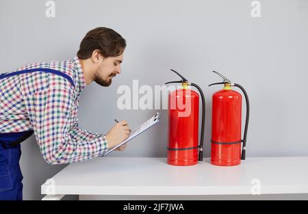 Male mechanic check fire extinguisher balloon Stock Photo