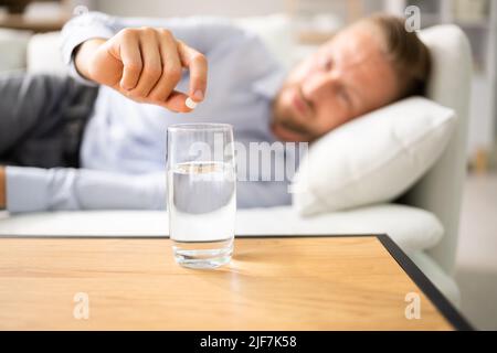 Man With Hangover Taking Medicine Pill Cure Stock Photo