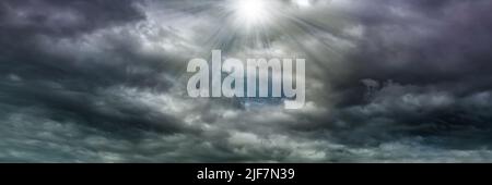 The rays of the sun break through the clouds, dramatic stormy sky, dark clouds before the rain. Stock Photo