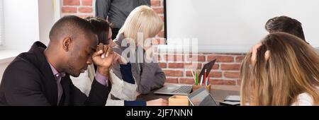 Diverse Tired Young Businesspeople Bored During Meeting In Office Stock Photo