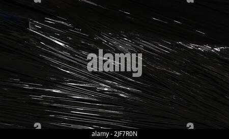 Shiny black plastic packing foil simple dark background texture, minimal backdrop, large piece of clean industrial black foil material structure, deta Stock Photo