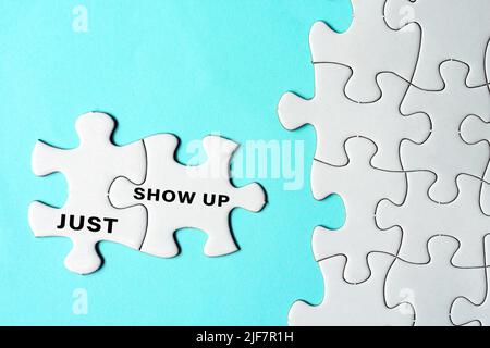 Just show up text on two pieces of white jigsaw puzzle on blue background. Stock Photo