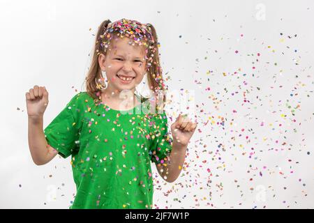 Confetti rain. Portrait of a child with multi-colored tinsel and confetti. Having fun celebrating her birthday. Confetti shower Stock Photo