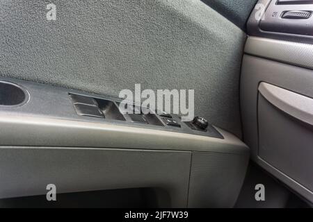 Controls on the door handle inside a car for adjusting and controlling windows and door locks Stock Photo