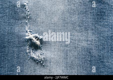 Close-up of hole in the jeans pants, texture background Stock Photo