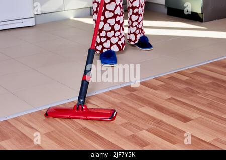 Housework with using flat mop to mopping floor in kitchen. Stock Photo