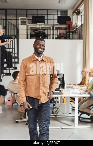 Young businessman with digital tablet standing in tech start-up office Stock Photo