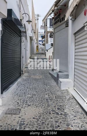 Santorini, Greece - May 13, 2021 : A typical empty alley in the center of Fira Santorini with closed shops and stores due to Covid Stock Photo