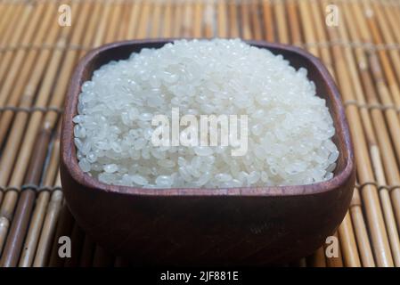 close up of japanese rice in a wooden cup. Japonica rice grains. sometimes called sinica rice, is one of the two major domestic types of Asian rice va Stock Photo
