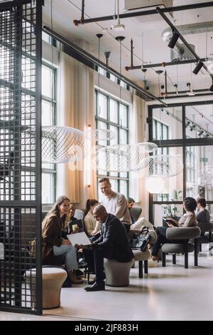 Businessmen and businesswomen working together in creative office Stock Photo