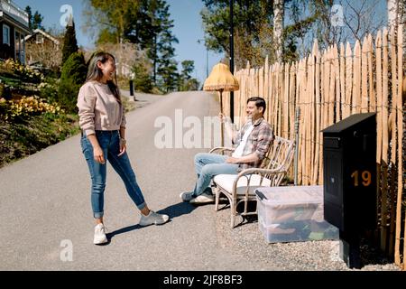 Smiling couple taking break while relocating to new house Stock Photo